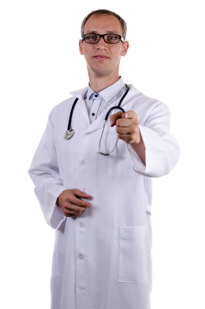 Doctor en gafas y con un abrigo blanco señala el dedo hacia adelante contra un fondo blanco
 - Foto, imagen
