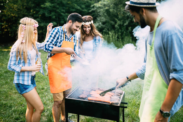 Cheerful friends spending time in nature and having barbecue - Photo, image