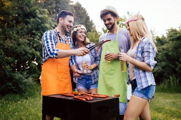 Cheerful friends spending time in nature and having barbecue - 写真・画像