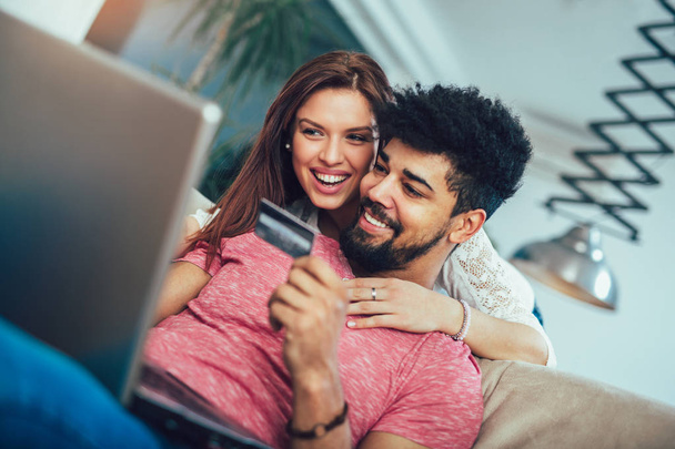 Uomo con laptop e donna in possesso di carta di credito a casa, concetto di shopping online
 - Foto, immagini
