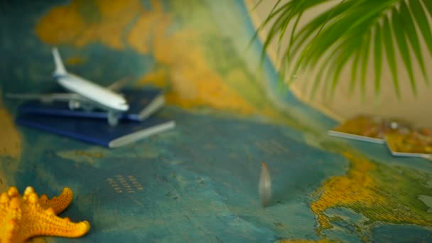 Time to travel concept. Tropical vacation theme with world map, blue passport and plane. Preparing for holliday, journey - Footage, Video