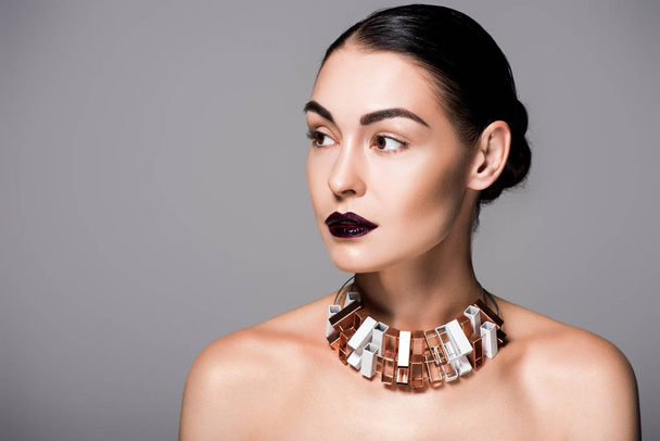 portrait of stylish nude girl posing wit black lips and trendy necklace, isolated on grey - Foto, afbeelding