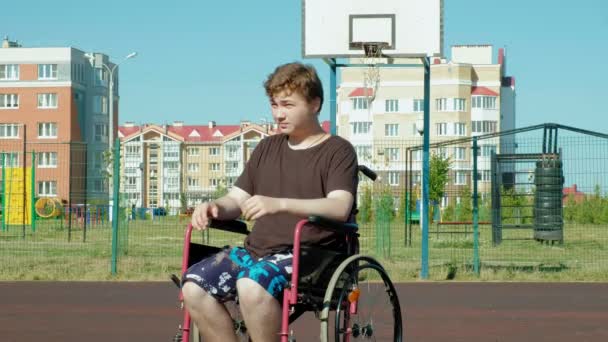 Niepełnosprawny mężczyzna gra koszykówki z wózku, na wolnym powietrzu, podjąć wysiłek podczas odtwarzania - Materiał filmowy, wideo