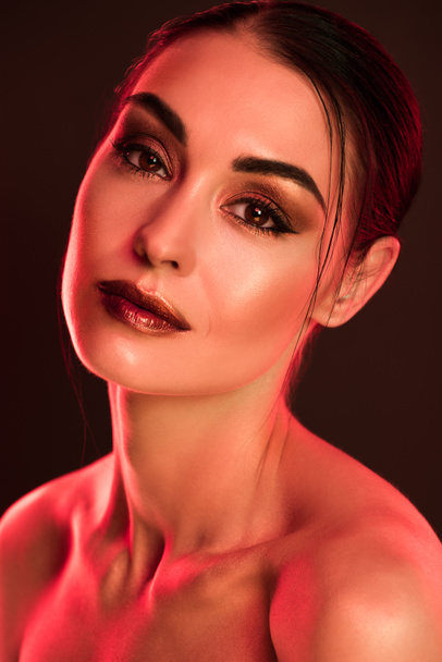 portrait of beautiful model with makeup posing for fashion shoot, red toned picture - Fotó, kép