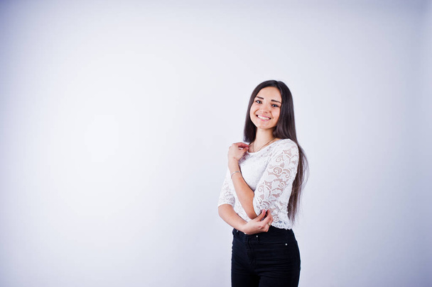Portrait of an elegant young woman in white top and black pants in the studio. - Foto, afbeelding