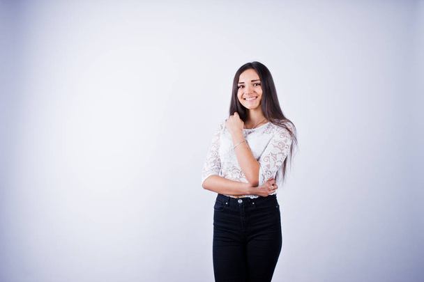Portrait of an elegant young woman in white top and black pants in the studio. - Photo, Image