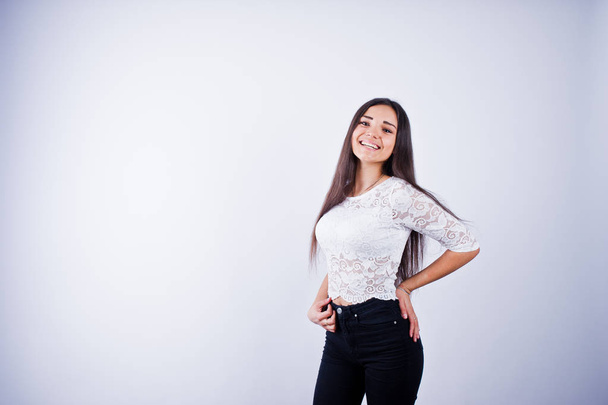 Portrait of an elegant young woman in white top and black pants in the studio. - Foto, Imagem