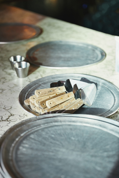 servidores de pizza acostados en bandeja de metal en la mesa de mármol en la cocina del restaurante
 - Foto, imagen