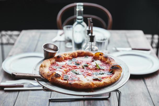 close-up shot of freshly baked pizza margherita on metal tray at restaurant - 写真・画像