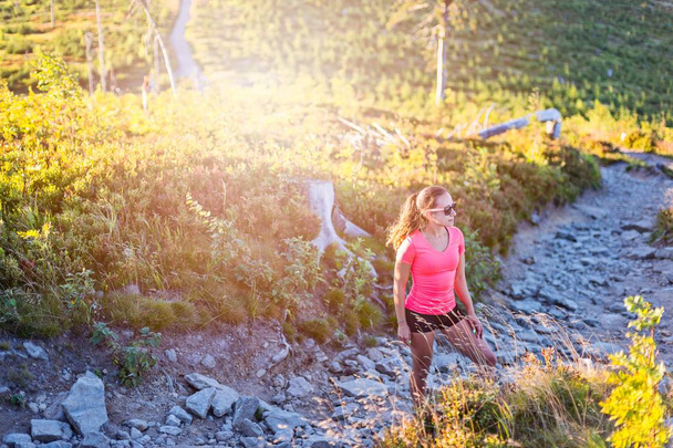 Young beautiful woman running in mountains. Woman trail runner - Photo, Image