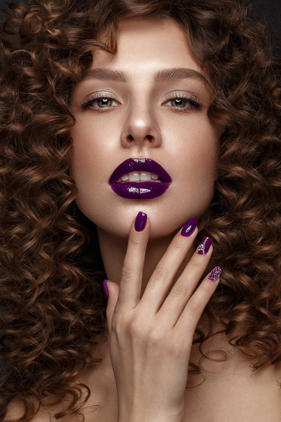 Beautiful girl with evening make-up, purple lips, curls and design manicure nails. beauty face. - Valokuva, kuva