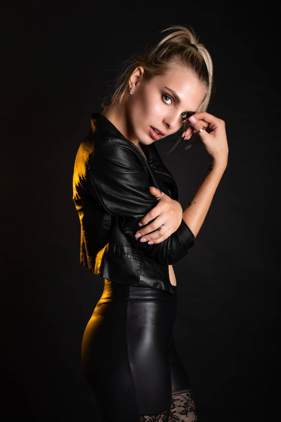 blonde Russian model dark leather - Fotoğraf, Görsel
