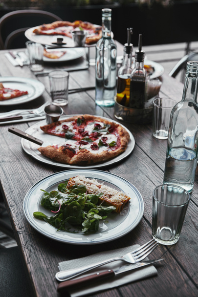 smaczne dania kuchni włoskiej i napoje na drewnianym stole rustykalnej restauracji - Zdjęcie, obraz