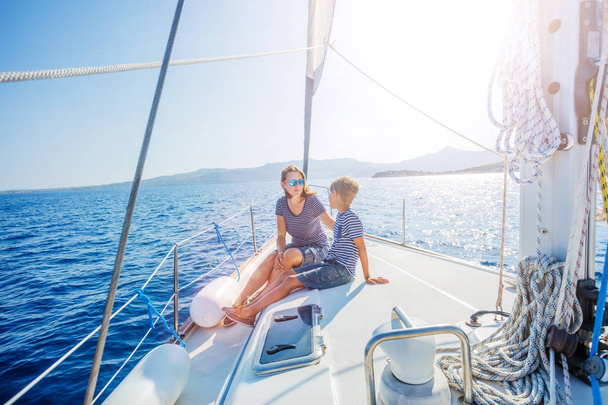 Boy with his mother on board of sailing yacht on summer cruise. - Fotoğraf, Görsel