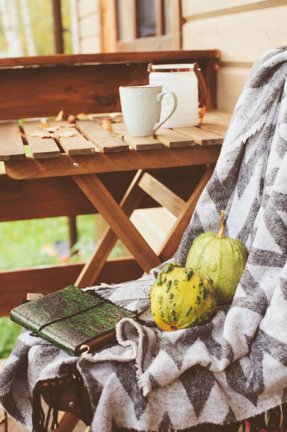 cozy autumn morning at country house, cup of tea and warm blanket on wooden table. Still life details - Foto, Imagem