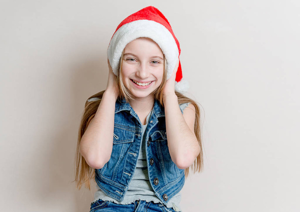 Cute young girl in santa claus hat with crossed arms - Фото, зображення