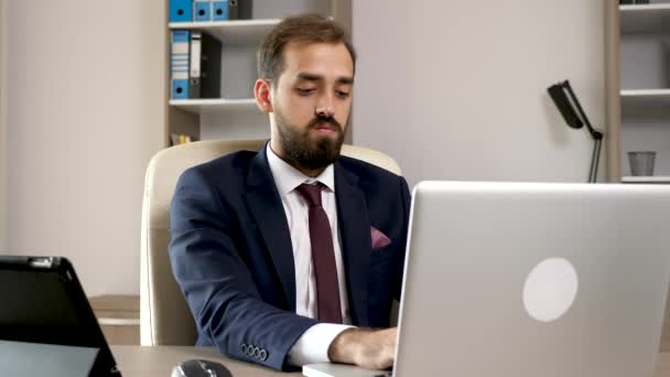 Multitasking in the office. Young entrepreneur working on the laptop - Video, Çekim