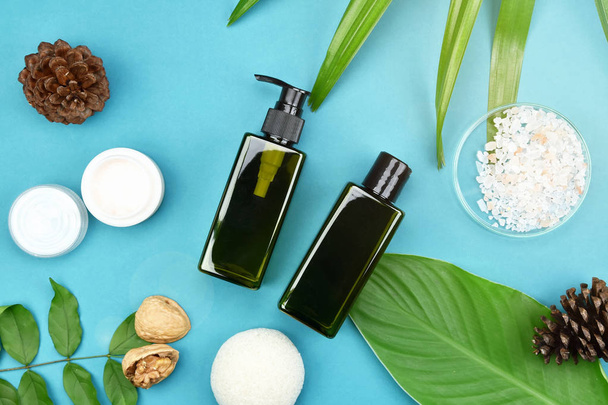 Kosmetische Hautpflege Flaschenbehälter mit grünen Kräuterblättern, leere Etikettenverpackung für Branding-Mock-Up, natürliches Bio-Beauty-Produktkonzept. - Foto, Bild