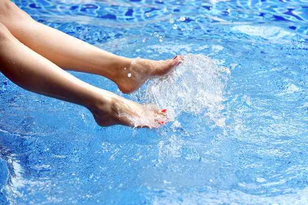 Ciesz się piękną dziewczyną relaks w basenie, nogi kobiety w wodzie, Strona wakacji. - Zdjęcie, obraz