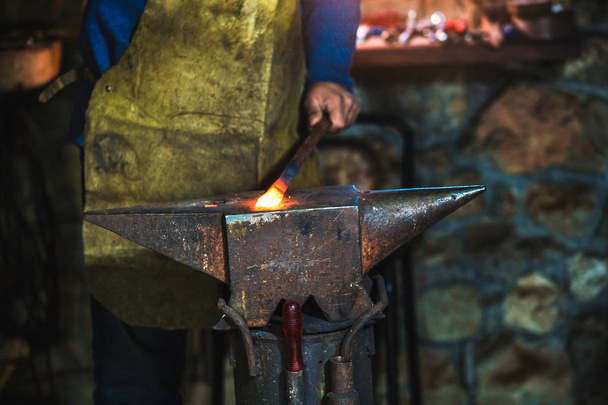 Smid smeden handmatig gesmolten metaal op een aambeeld in smithy met vonk vuurwerk, close-up - Foto, afbeelding