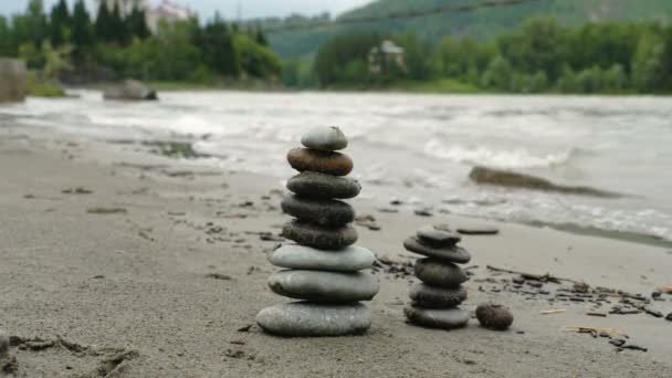 kleine Türme aus runden Steinen am Strand - Filmmaterial, Video