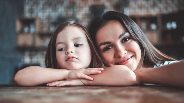 Attractive young woman and her little cute daughter are on kitchen. Mom and girl are tired after cooking. - Fotoğraf, Görsel