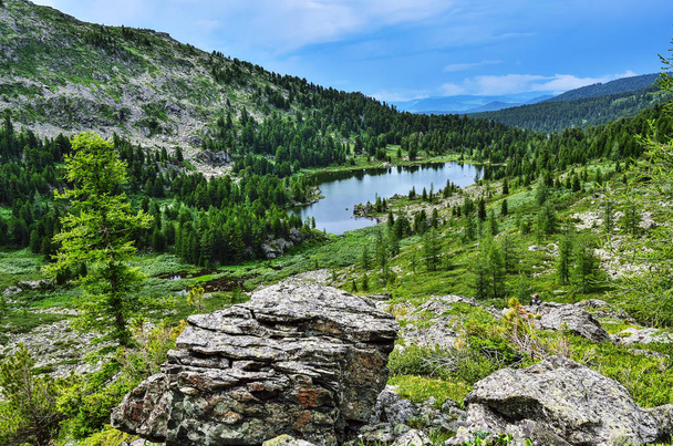 Uno de los siete lagos más limpios de Karakol, ubicado en el valle al pie del paso Bagatash, montañas Altai, Rusia. Paisaje nublado de verano con rocas en primer plano
 - Foto, imagen