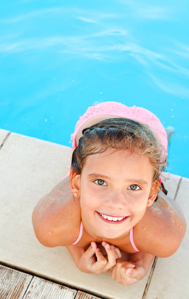Cute smiling happy little girl child  in swimming pool in summer day - Foto, afbeelding