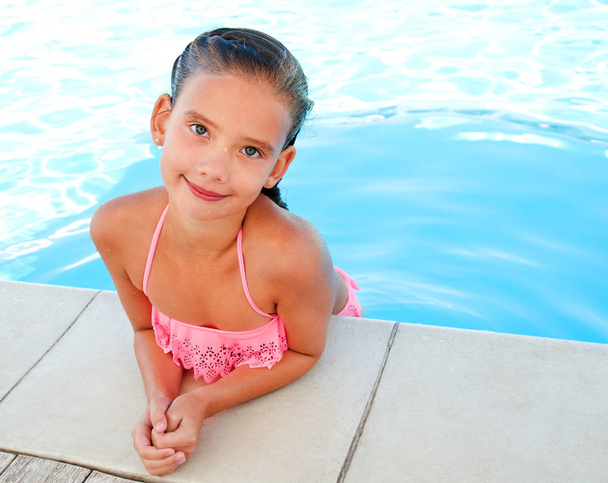 Cute smiling happy little girl child  in swimming pool in summer day - Foto, Bild