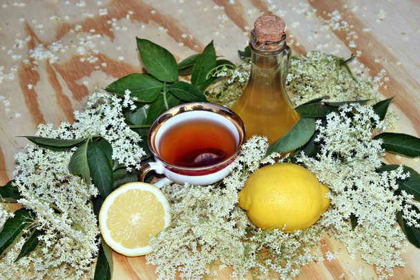 Syrop z kwiatu czarnego bzu z herbaty na podłoże drewniane i świeże kwiaty - Zdjęcie, obraz