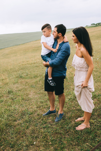 parents and son standing on green field - 写真・画像