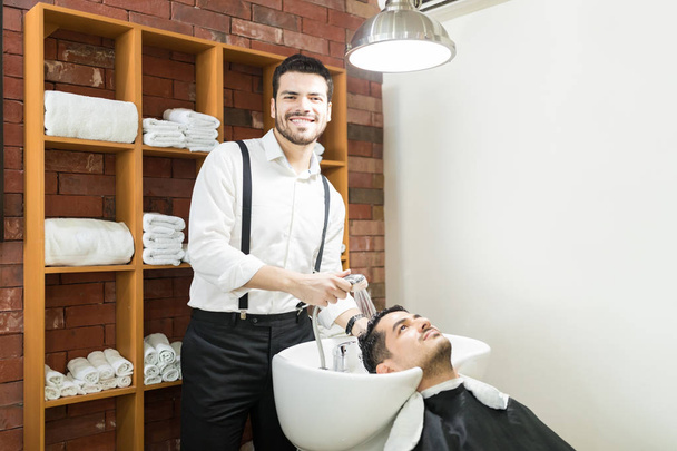 Dükkanda duşlu müşterinin saç yıkarken gülümseyerek emin Kuaför - Fotoğraf, Görsel