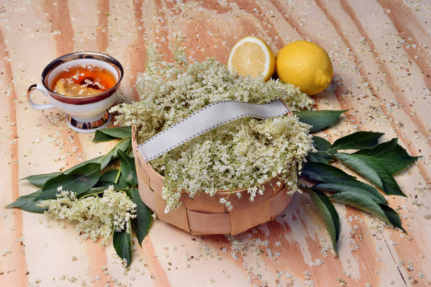 Gezondheid thee uit Vlierbes bloemen op een houten tafel - Foto, afbeelding