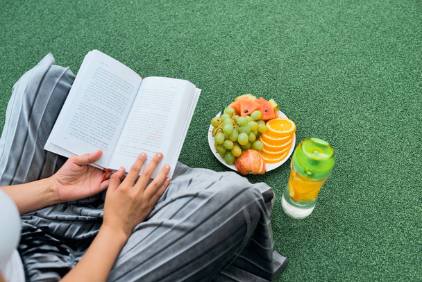 緑の芝生、平面図、作物の上に座って本を読む女性 - 写真・画像
