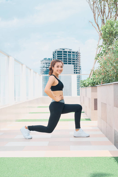 Молодая азиатка в спортивной одежде занимается спортом на открытом воздухе
 - Фото, изображение