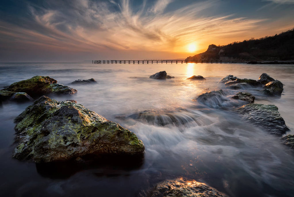 Rocky ranta pitkä altistuminen meri auringonlasku
 - Valokuva, kuva