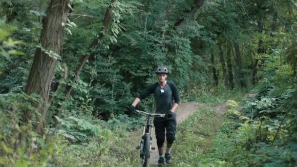 extreme cyclist comes with bicycle in forest, slow motion - Video