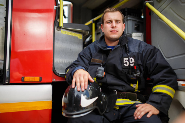Photo of fireman sitting in fire truck - Fotografie, Obrázek