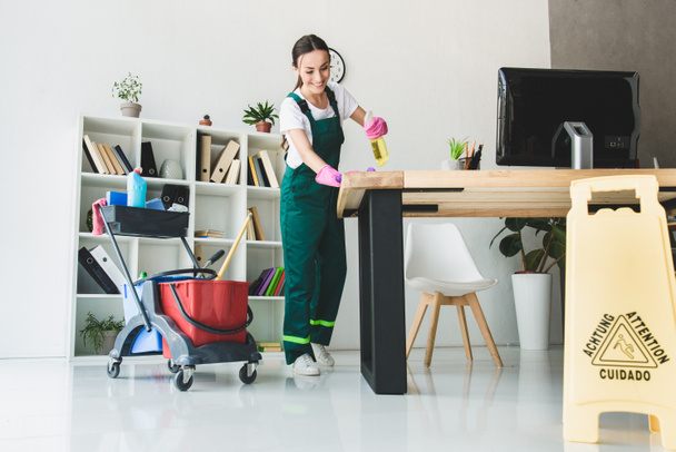 alacsony, szög, kilátás a mosolygó fiatal gondnok modern irodai takarítás - Fotó, kép