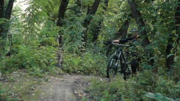 extreme cyclist comes with bicycle in forest, slow motion - Filmati, video