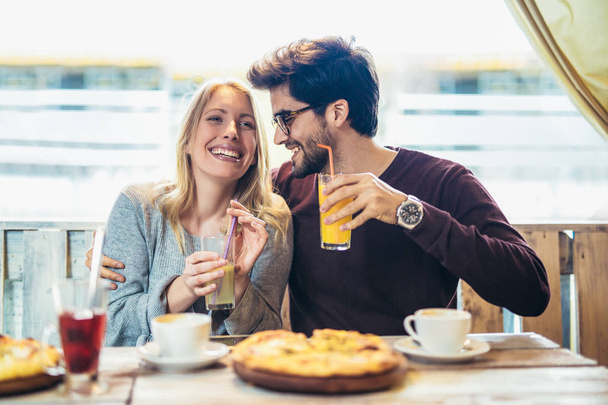 Hymyilevä pari nauttii pizzakahvilassa ja hauskaa yhdessä
 - Valokuva, kuva