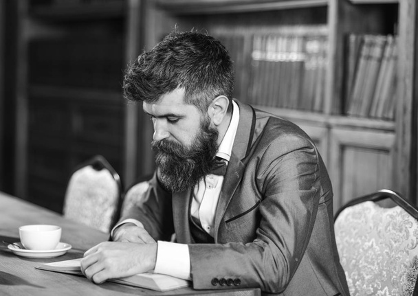 Bearded man reading and drinking tea or coffee. Bearded man concept. - 写真・画像