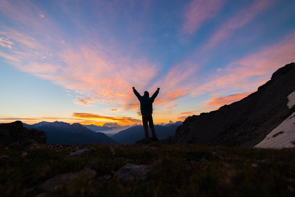Ember állt a mountain top outstretching arms, napfelkelte fényében színes égbolt scenis táj, a honfoglaló sikerrel leader koncepció. - Fotó, kép