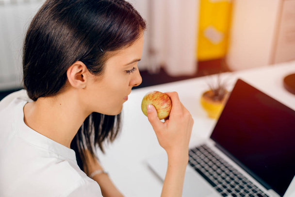Woman in office holding an apple - Φωτογραφία, εικόνα