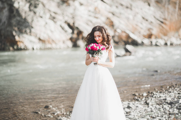 Portrait of stunning bride with long hair posing with great bouquet - Photo, image