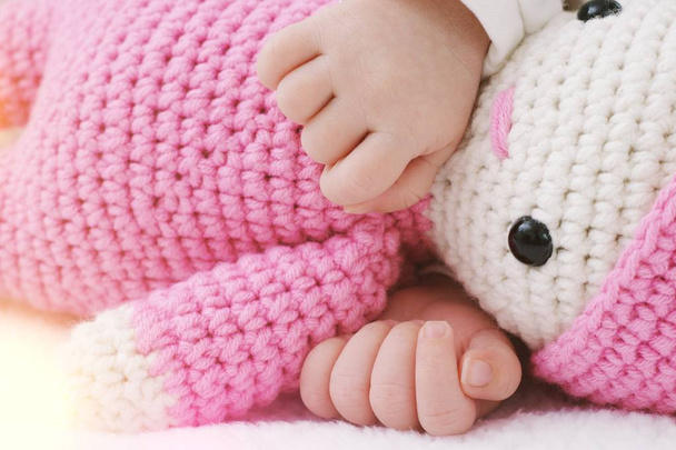 生まれたばかりの赤ちゃんピンクのおもちゃ赤ちゃんと一緒に眠るし、抱擁を手 - 写真・画像