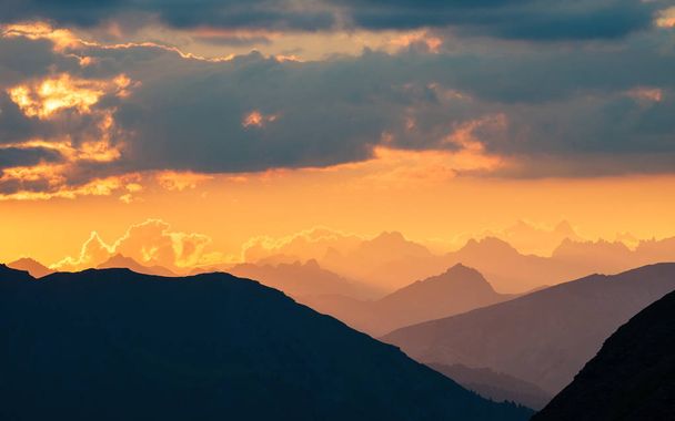 The Alps at sunrise. Colorful sky majestic mountain peaks, fog mist valleys. Sunburst and backlight expansive view from above. - Fotó, kép