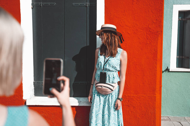 Two travel girls making photo each other on Burano island, Venice, Italy. - Photo, Image