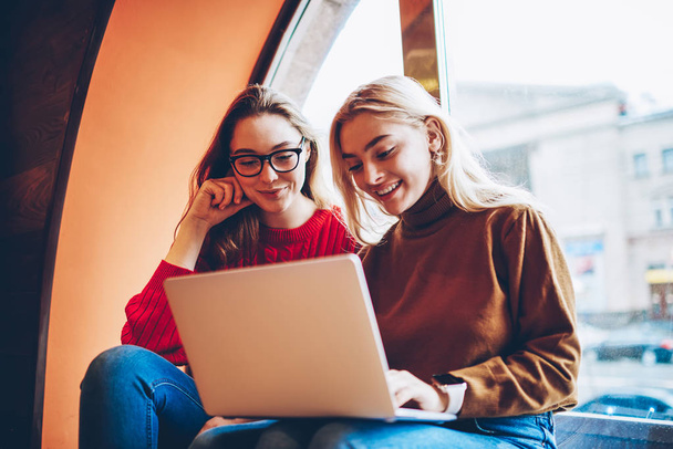 Positiivinen naisopiskelijat nauttivat katsomassa koulutusta webinar yhdessä langattoman yhteyden ja kannettavan tietokoneen coworking tilaa, nuoret tytöt ystäviä hauskaa verkostoitumista netbook vapaa
  - Valokuva, kuva
