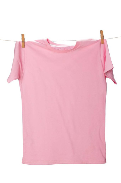 Blank pink colored t-shirt hanging on clothesline  - Fotografie, Obrázek
